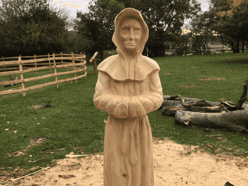 a wooden sculpture of a monk